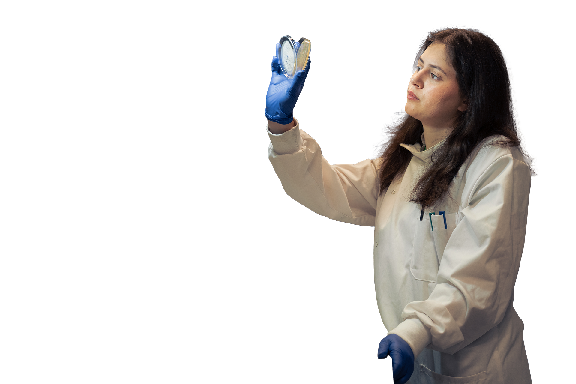 A student looks quizzically at her hand which holds scientific equipment